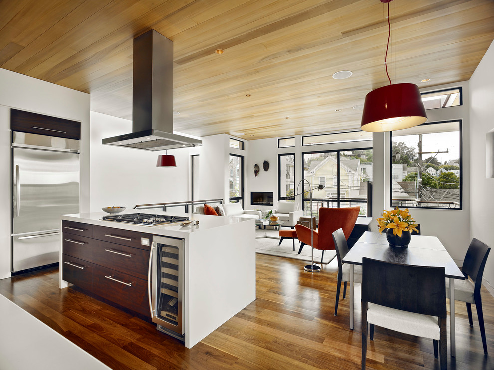 Esempio di una cucina ad ambiente unico minimal con ante lisce, ante in legno bruno e elettrodomestici in acciaio inossidabile