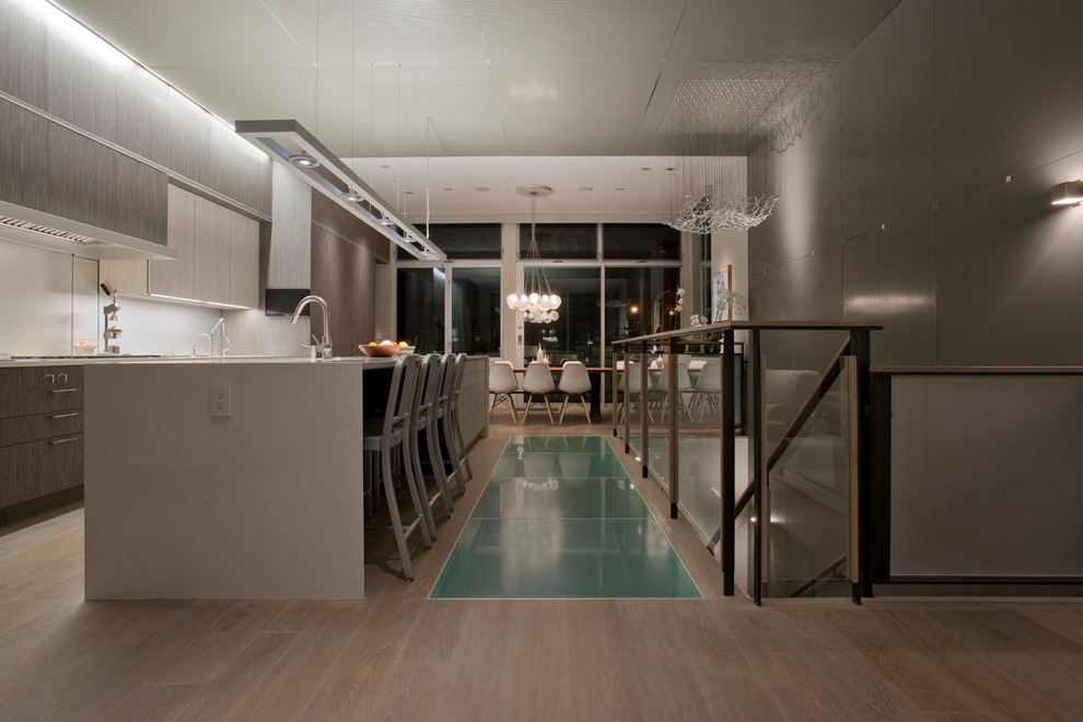 サンフランシスコにあるコンテンポラリースタイルのおしゃれなキッチン (フラットパネル扉のキャビネット、グレーのキャビネット、白いキッチンパネル) の写真