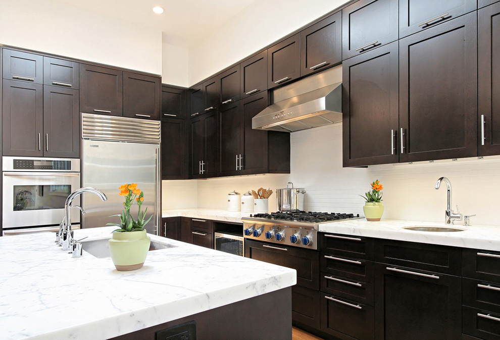 Klassische Küche mit Küchengeräten aus Edelstahl, Unterbauwaschbecken, Marmor-Arbeitsplatte, Schrankfronten im Shaker-Stil, dunklen Holzschränken und Küchenrückwand in Weiß in San Francisco