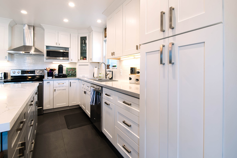 Inredning av ett modernt stort vit vitt kök, med en undermonterad diskho, skåp i shakerstil, vita skåp, marmorbänkskiva, vitt stänkskydd, stänkskydd i keramik, rostfria vitvaror, skiffergolv, en köksö och svart golv