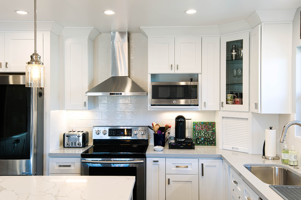 Foto di una grande cucina minimalista con lavello sottopiano, ante in stile shaker, ante bianche, top in marmo, paraspruzzi bianco, paraspruzzi con piastrelle in ceramica, elettrodomestici in acciaio inossidabile, pavimento in ardesia, pavimento nero e top bianco