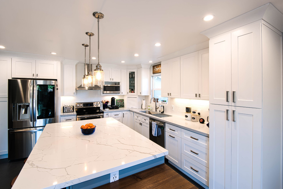 Inspiration for a large modern u-shaped slate floor and black floor eat-in kitchen remodel in San Francisco with an undermount sink, shaker cabinets, white cabinets, marble countertops, white backsplash, ceramic backsplash, stainless steel appliances, an island and white countertops