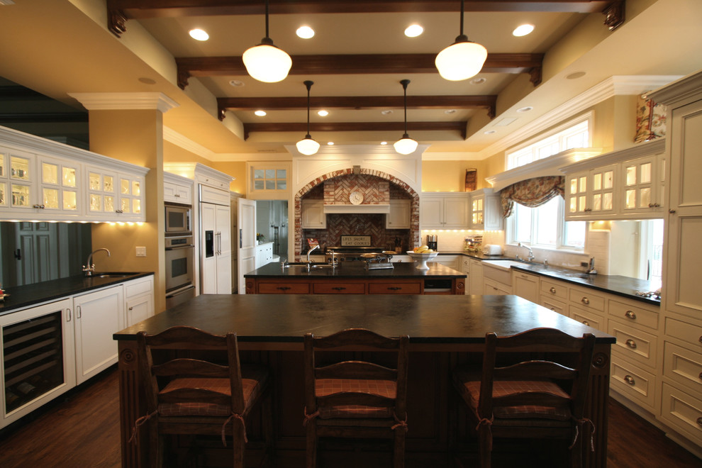 Eat-in kitchen - huge french country galley dark wood floor eat-in kitchen idea in Orange County with a farmhouse sink, soapstone countertops, white backsplash, subway tile backsplash, stainless steel appliances, two islands, recessed-panel cabinets and white cabinets