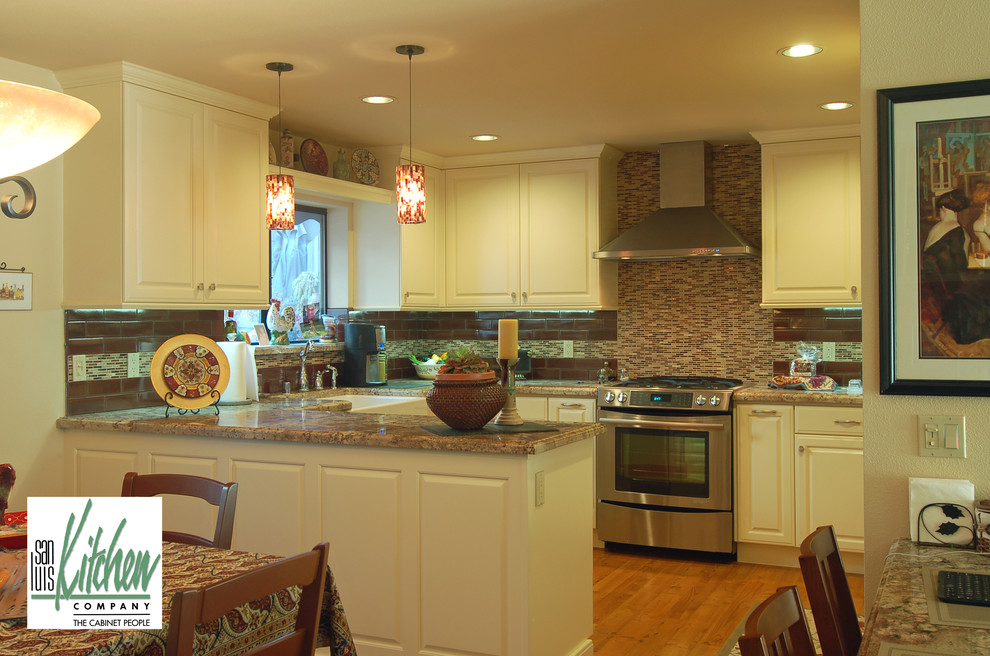 Idéer för ett mellanstort klassiskt kök, med en rustik diskho, luckor med upphöjd panel, vita skåp, granitbänkskiva, brunt stänkskydd, rostfria vitvaror, mellanmörkt trägolv och en halv köksö