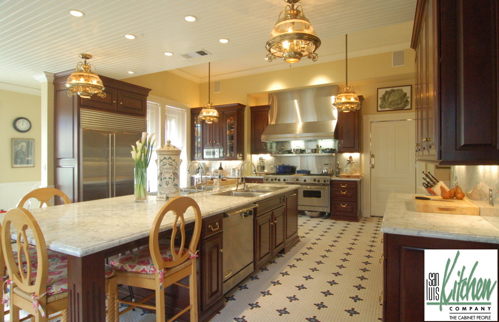 Exempel på ett avskilt klassiskt u-kök, med en nedsänkt diskho, luckor med upphöjd panel, skåp i mörkt trä, marmorbänkskiva, vitt stänkskydd, stänkskydd i sten och rostfria vitvaror