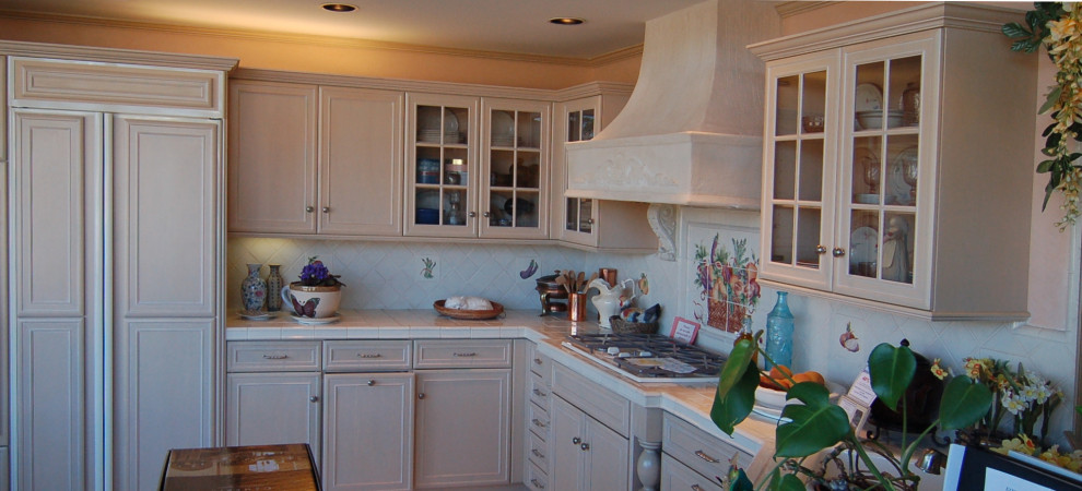 Exempel på ett mellanstort vit vitt kök, med en dubbel diskho, luckor med infälld panel, beige skåp, kaklad bänkskiva, vitt stänkskydd, stänkskydd i keramik, vita vitvaror, marmorgolv, en halv köksö och vitt golv