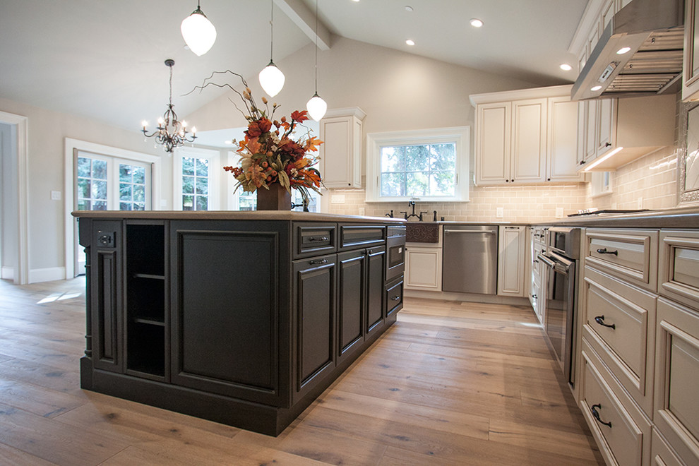 Kitchen pantry - large traditional u-shaped medium tone wood floor kitchen pantry idea in San Francisco with a farmhouse sink, raised-panel cabinets, white cabinets, quartz countertops, brown backsplash, ceramic backsplash, stainless steel appliances and an island