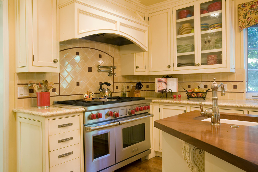 Exempel på ett stort medelhavsstil kök, med luckor med infälld panel, beige skåp, träbänkskiva, flerfärgad stänkskydd, stänkskydd i keramik, rostfria vitvaror, en undermonterad diskho, mellanmörkt trägolv och en köksö