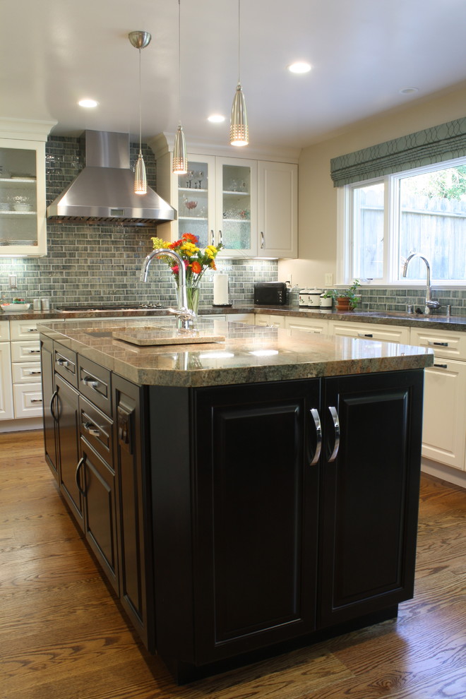 Immagine di una cucina minimal con lavello a vasca singola, ante di vetro, ante bianche, top in granito e elettrodomestici in acciaio inossidabile