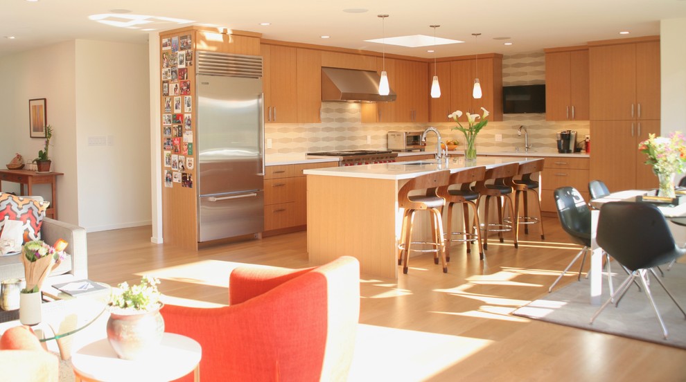 На фото: кухня в стиле модернизм с плоскими фасадами, светлыми деревянными фасадами, столешницей из кварцевого агломерата, фартуком из керамической плитки, светлым паркетным полом, островом и белой столешницей