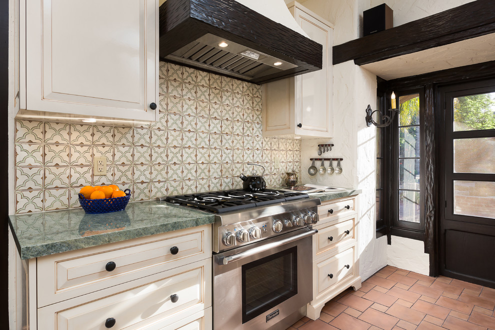 Enclosed kitchen - mid-sized mediterranean single-wall terra-cotta tile and brown floor enclosed kitchen idea in Los Angeles with an undermount sink, raised-panel cabinets, white cabinets, marble countertops, multicolored backsplash and ceramic backsplash
