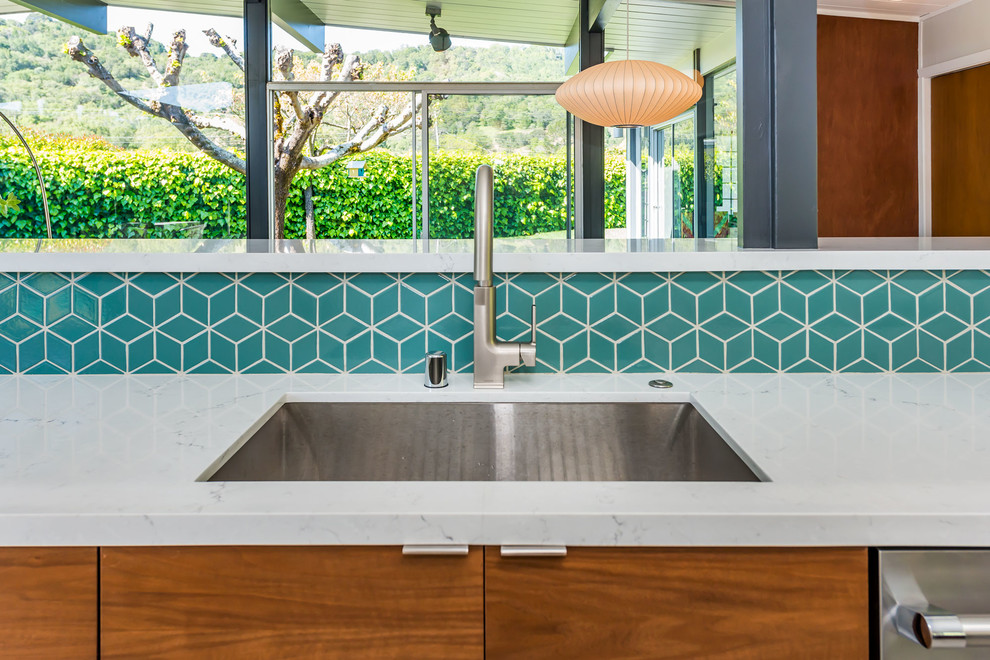 Photo of a medium sized midcentury single-wall open plan kitchen in San Francisco with a built-in sink, flat-panel cabinets, white cabinets, quartz worktops, blue splashback, ceramic splashback, stainless steel appliances, painted wood flooring, a breakfast bar, grey floors and white worktops.