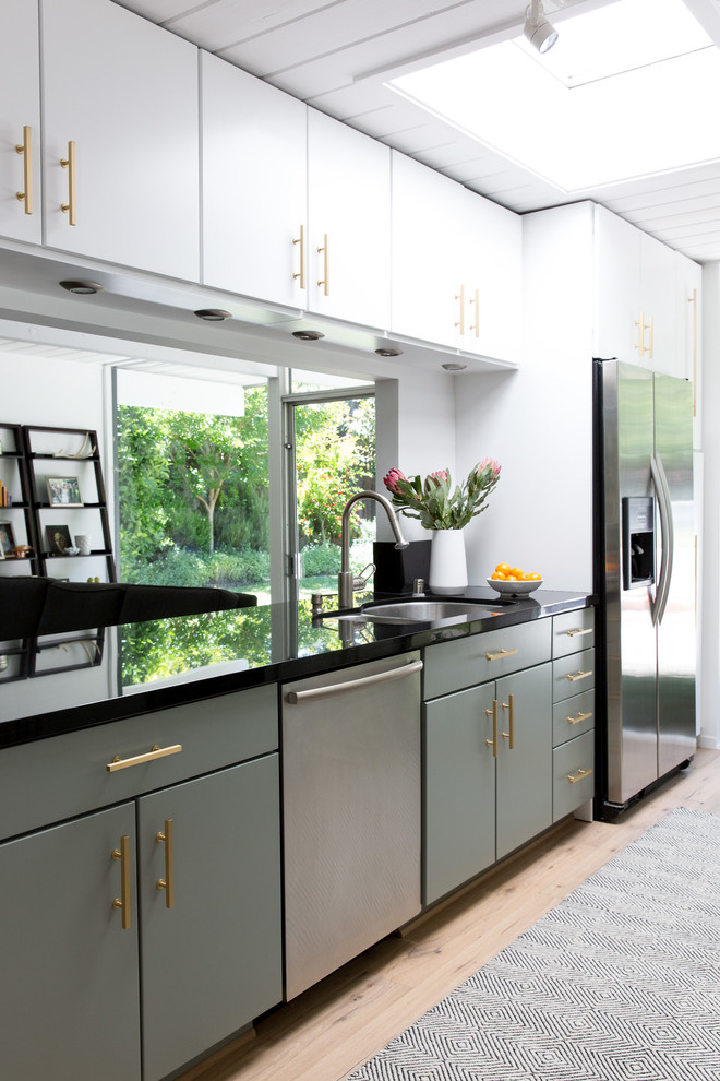 Foto på ett mellanstort 50 tals kök, med en undermonterad diskho, släta luckor, gröna skåp, bänkskiva i kvarts, rostfria vitvaror, ljust trägolv och vitt golv