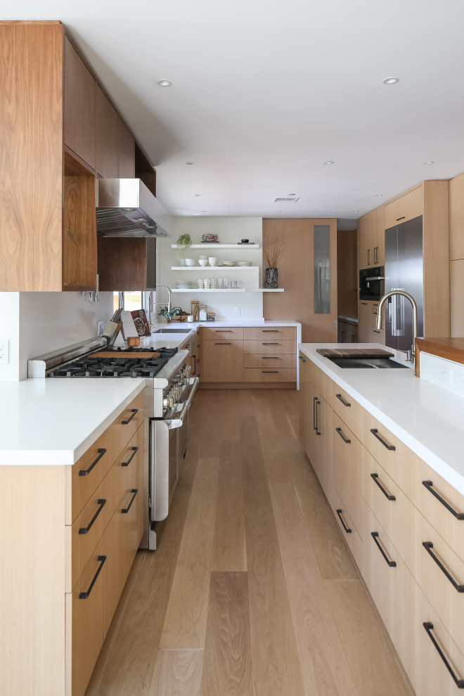 Idées déco pour une cuisine ouverte contemporaine en bois clair avec un placard à porte plane et îlot.
