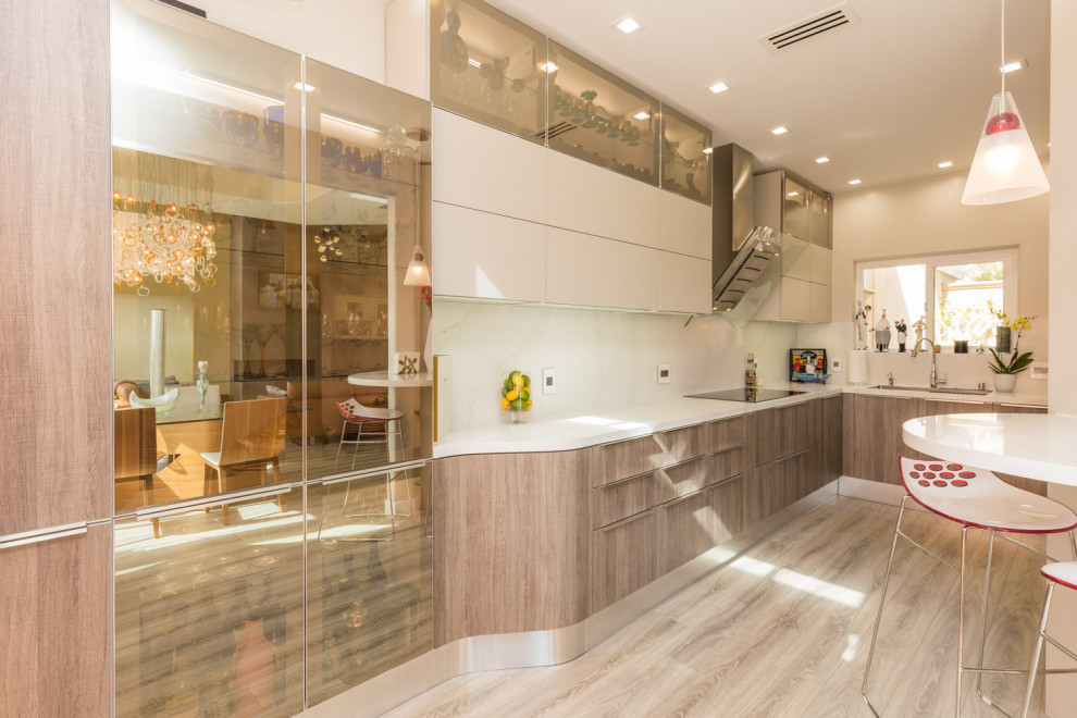 This is an example of a medium sized modern l-shaped enclosed kitchen in San Francisco with a built-in sink, flat-panel cabinets, brown cabinets, engineered stone countertops, white splashback, stainless steel appliances, laminate floors, no island, grey floors and white worktops.