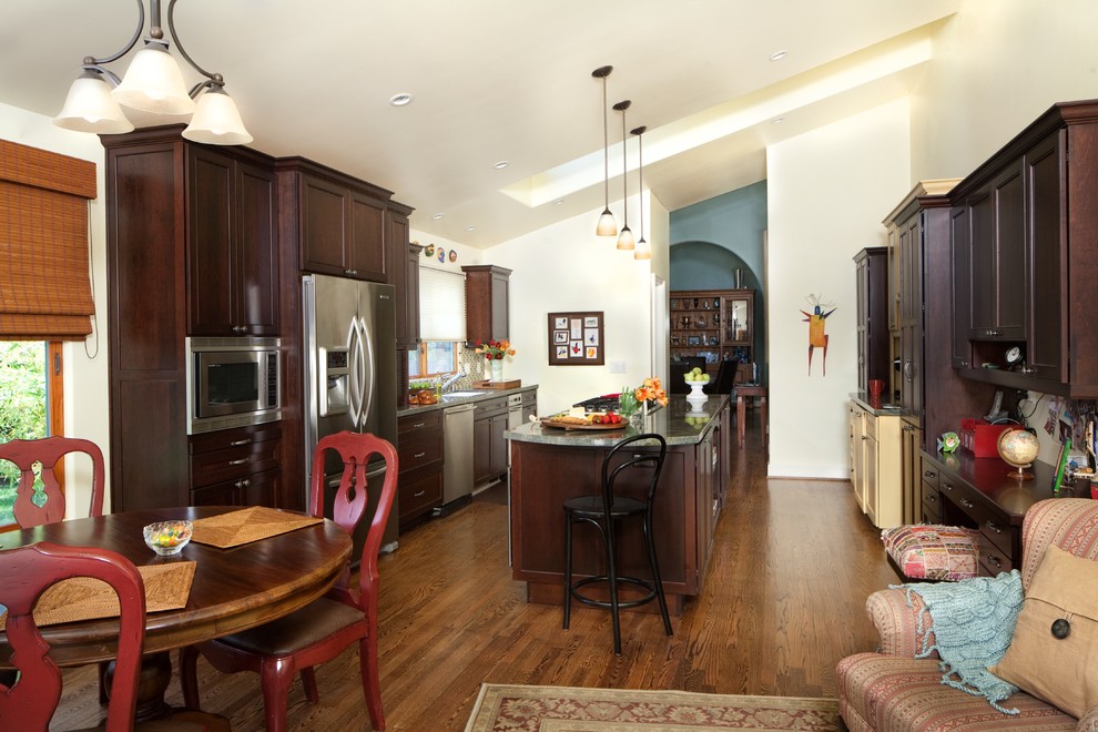 Große Klassische Wohnküche mit dunklen Holzschränken, Küchengeräten aus Edelstahl, braunem Holzboden und Kücheninsel in Santa Barbara