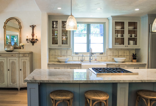 Rustic kitchen with marble island, patterned glass backsplash, and vintage-style cabinets – cozy Canadian home design
