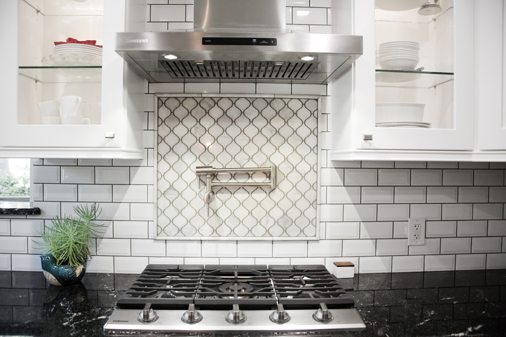 Idéer för ett mellanstort modernt svart kök, med en enkel diskho, skåp i shakerstil, vita skåp, granitbänkskiva, vitt stänkskydd, stänkskydd i porslinskakel, rostfria vitvaror, klinkergolv i porslin, en halv köksö och grått golv