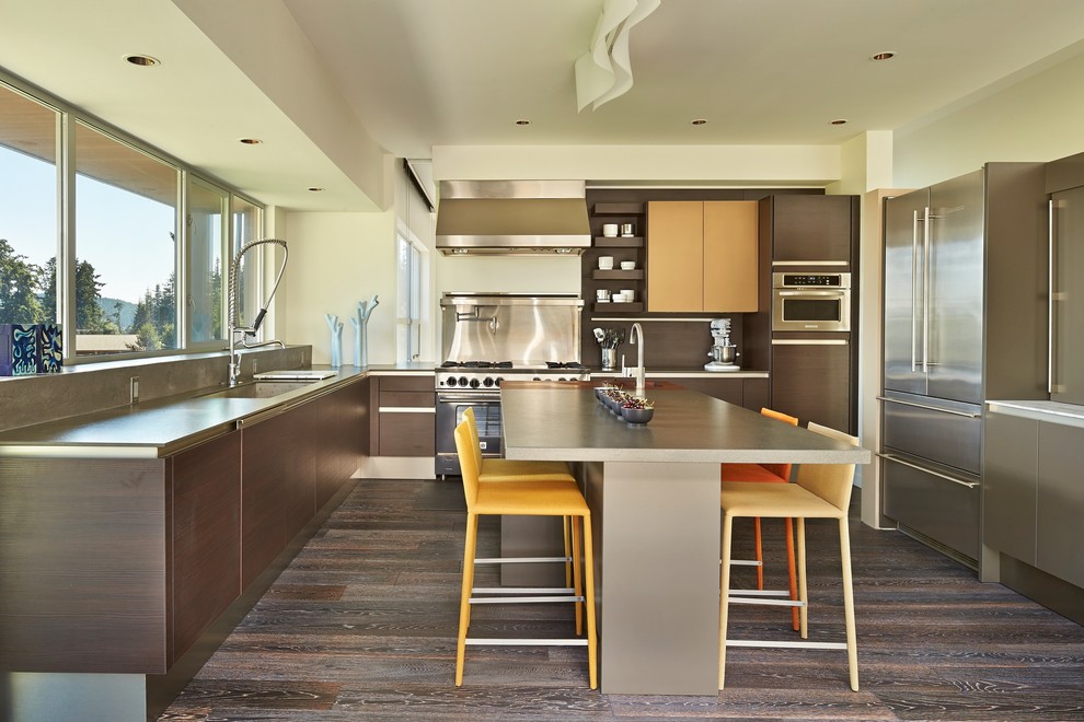 This is an example of a contemporary u-shaped kitchen in Seattle with flat-panel cabinets, dark wood cabinets, stainless steel appliances, dark hardwood flooring and an island.