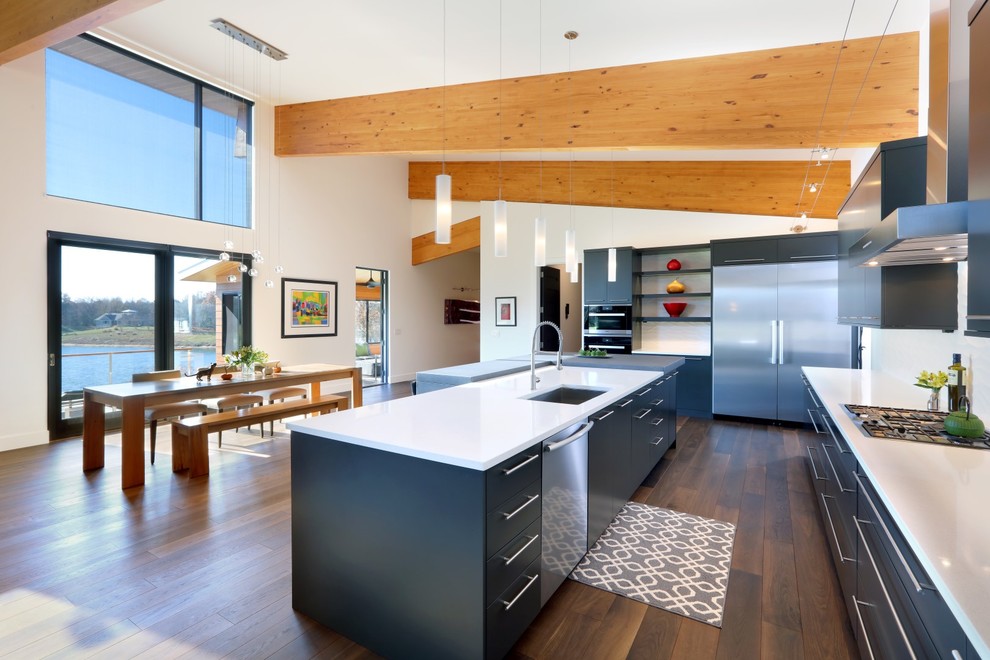 Inspiration for a contemporary kitchen/diner in Grand Rapids with a submerged sink, flat-panel cabinets, black cabinets, stainless steel appliances, dark hardwood flooring and an island.