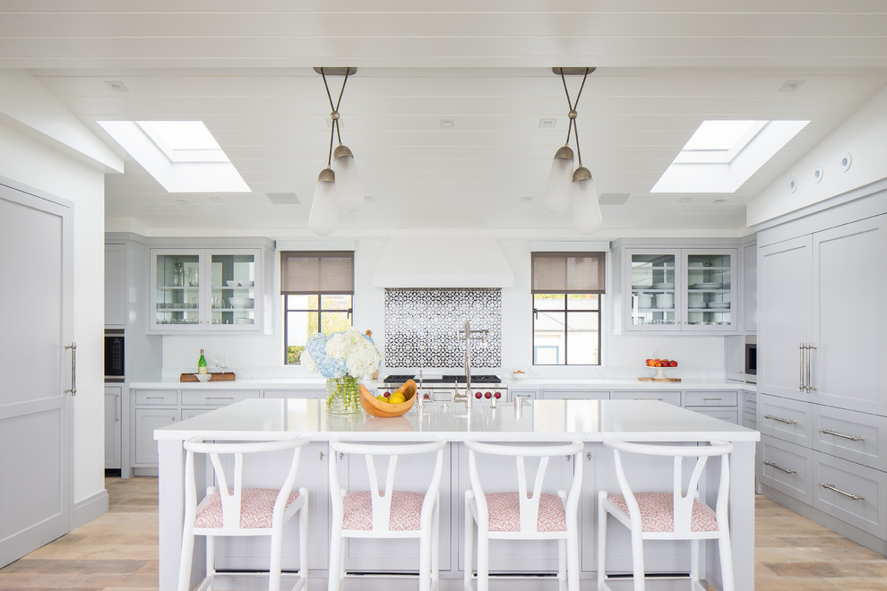 Bild på ett maritimt kök, med en rustik diskho, skåp i shakerstil, grå skåp, flerfärgad stänkskydd, integrerade vitvaror, ljust trägolv, en köksö och beiget golv