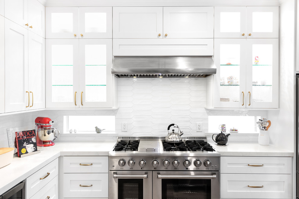 Exempel på ett mellanstort klassiskt vit vitt kök, med en undermonterad diskho, luckor med infälld panel, blå skåp, bänkskiva i kvarts, vitt stänkskydd, stänkskydd i tunnelbanekakel, rostfria vitvaror, ljust trägolv, en köksö och orange golv