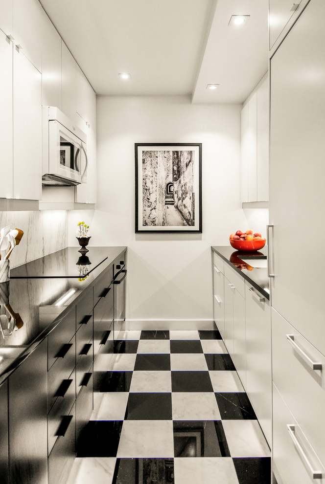 Inspiration for a mid-sized modern galley marble floor and multicolored floor enclosed kitchen remodel in San Francisco with an undermount sink, flat-panel cabinets, white cabinets, quartz countertops, multicolored backsplash, stone slab backsplash, paneled appliances, no island and black countertops