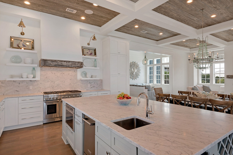 Inspiration for a huge tropical l-shaped dark wood floor and beige floor open concept kitchen remodel in Miami with a double-bowl sink, recessed-panel cabinets, white cabinets, marble countertops, white backsplash, stainless steel appliances, an island and marble backsplash