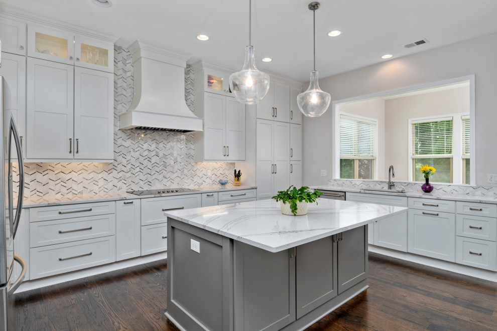 Example of a large transitional u-shaped dark wood floor and brown floor open concept kitchen design in Atlanta with a triple-bowl sink, shaker cabinets, white cabinets, quartzite countertops, white backsplash, marble backsplash, stainless steel appliances, an island and white countertops