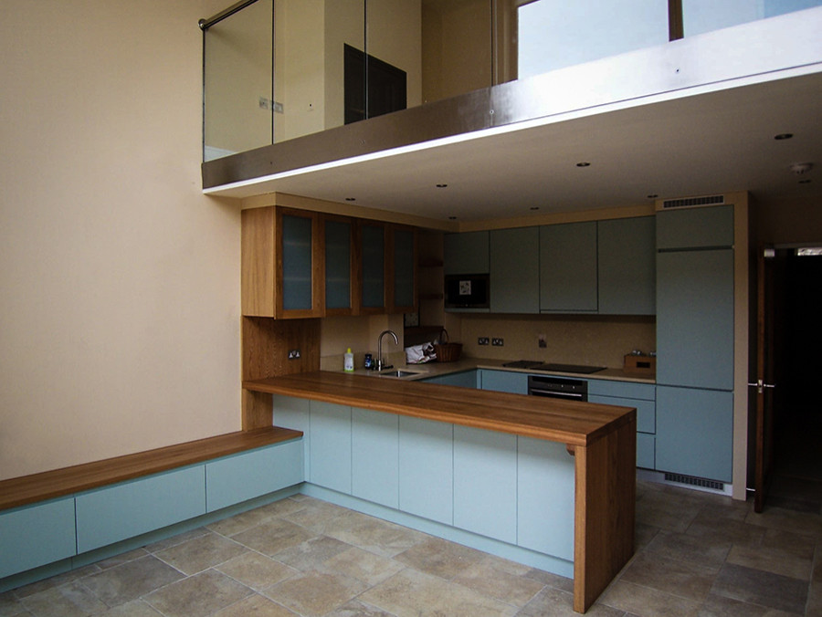 Esempio di una cucina minimal di medie dimensioni con lavello a vasca singola, ante lisce, ante blu, top in legno, paraspruzzi giallo, elettrodomestici da incasso e pavimento in marmo
