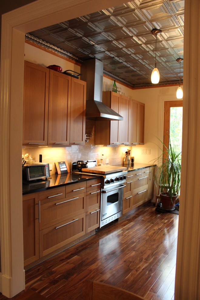 Bild på ett mellanstort eklektiskt kök, med en undermonterad diskho, skåp i shakerstil, skåp i mellenmörkt trä, granitbänkskiva, beige stänkskydd, stänkskydd i stenkakel, rostfria vitvaror och mellanmörkt trägolv