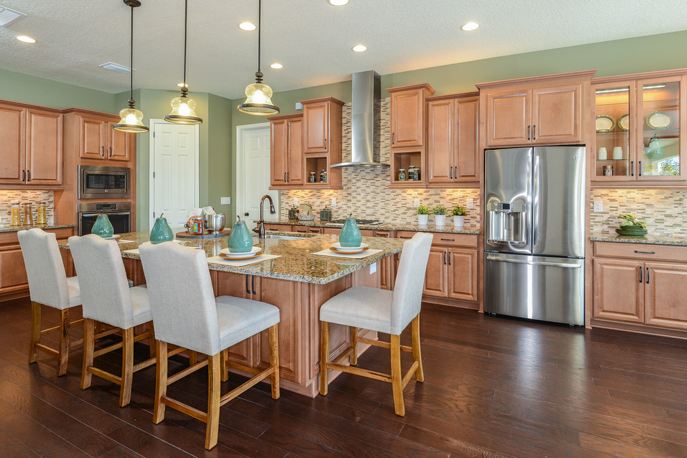 Mid-sized southwest l-shaped dark wood floor and brown floor kitchen photo in Tampa with raised-panel cabinets, light wood cabinets, stainless steel appliances and an island