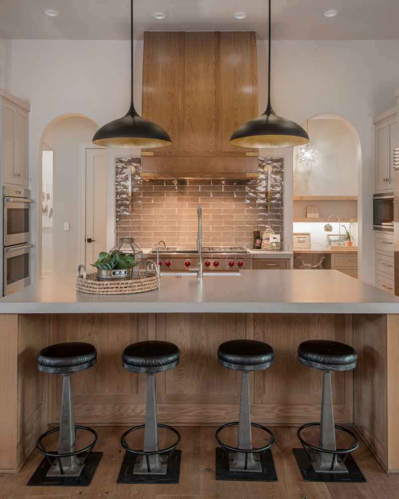 Klassische Küche in U-Form mit Landhausspüle, Schrankfronten im Shaker-Stil, beigen Schränken, Küchenrückwand in Braun, Küchengeräten aus Edelstahl, dunklem Holzboden und Kücheninsel in Austin