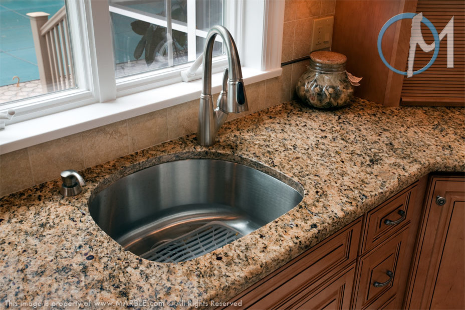 Immagine di una grande cucina minimal con ante in legno chiaro, top in granito, paraspruzzi beige e elettrodomestici in acciaio inossidabile