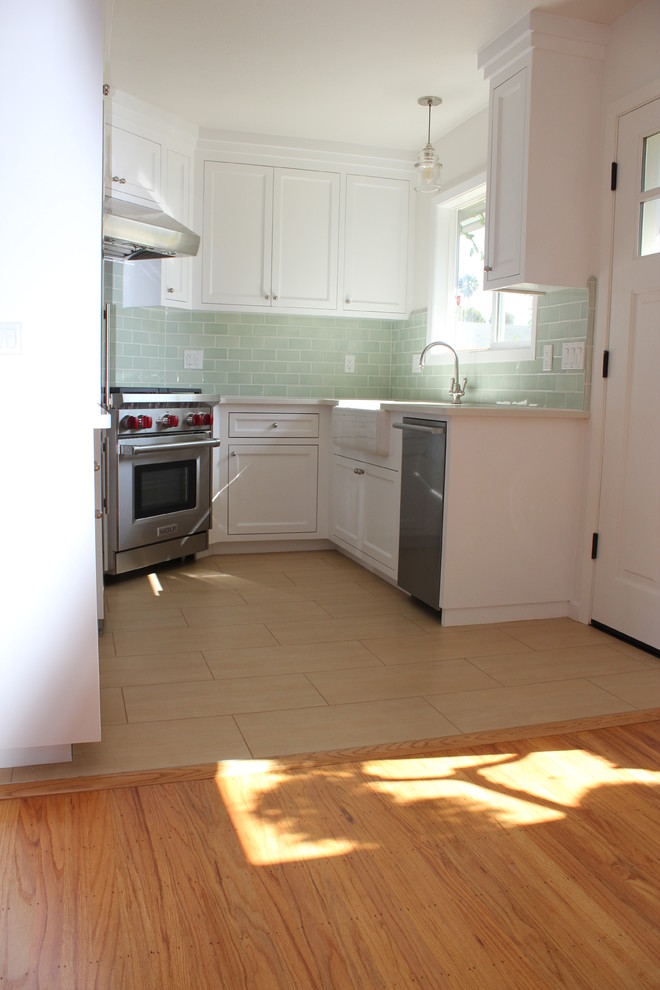 Exempel på ett litet maritimt kök, med en rustik diskho, vita skåp, bänkskiva i kvarts, grönt stänkskydd, stänkskydd i glaskakel och rostfria vitvaror