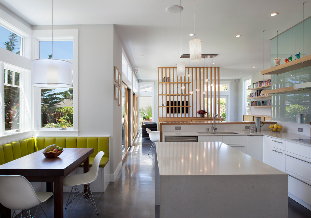 Idée de décoration pour une cuisine américaine design avec sol en béton ciré et îlot.
