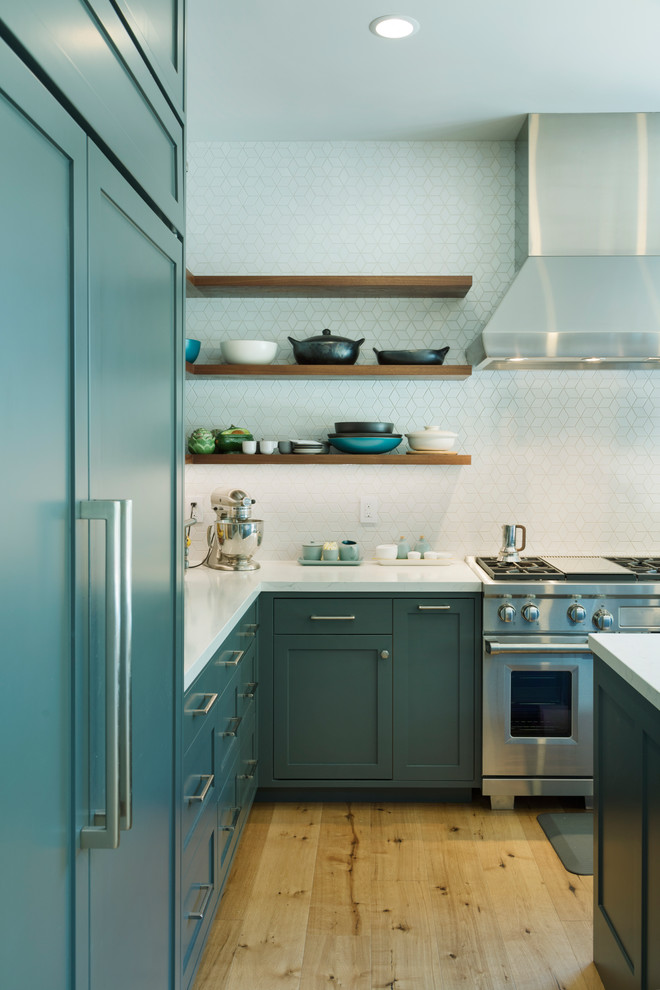 サンフランシスコにある高級な広いモダンスタイルのおしゃれなキッチン (エプロンフロントシンク、シェーカースタイル扉のキャビネット、青いキャビネット、クオーツストーンカウンター、白いキッチンパネル、セラミックタイルのキッチンパネル、シルバーの調理設備、淡色無垢フローリング、白いキッチンカウンター) の写真