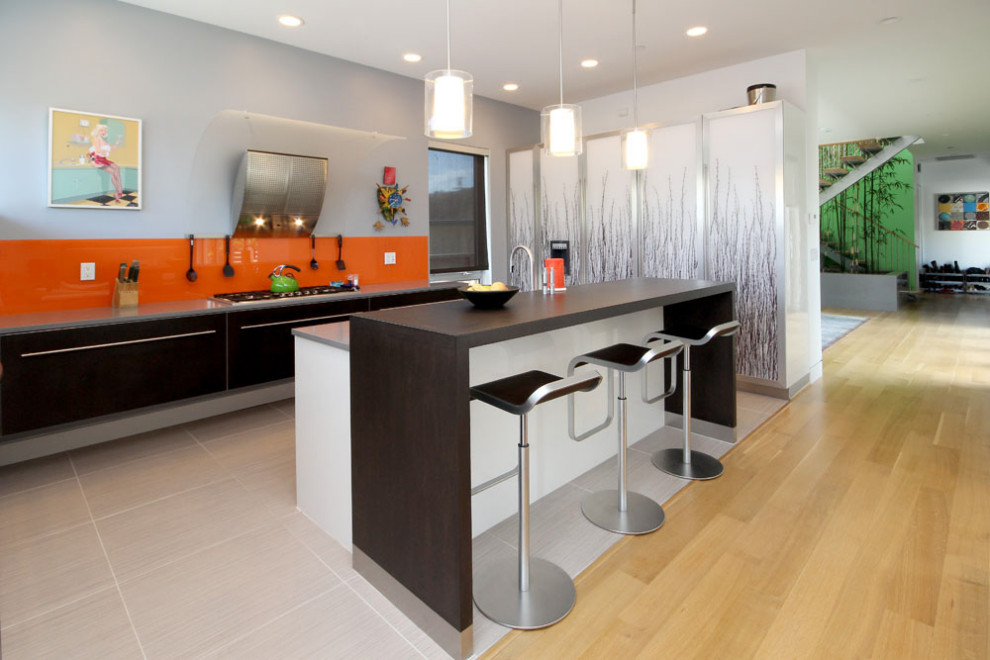 Foto de cocina ecléctica con armarios con paneles lisos, salpicadero naranja, una isla, suelo gris y encimeras grises