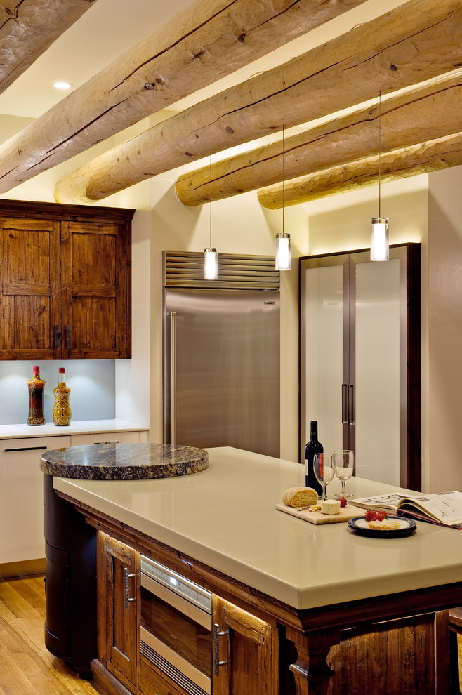 Inspiration for a large southwestern l-shaped enclosed kitchen remodel in Albuquerque with an undermount sink, flat-panel cabinets, white cabinets, solid surface countertops, glass sheet backsplash and stainless steel appliances