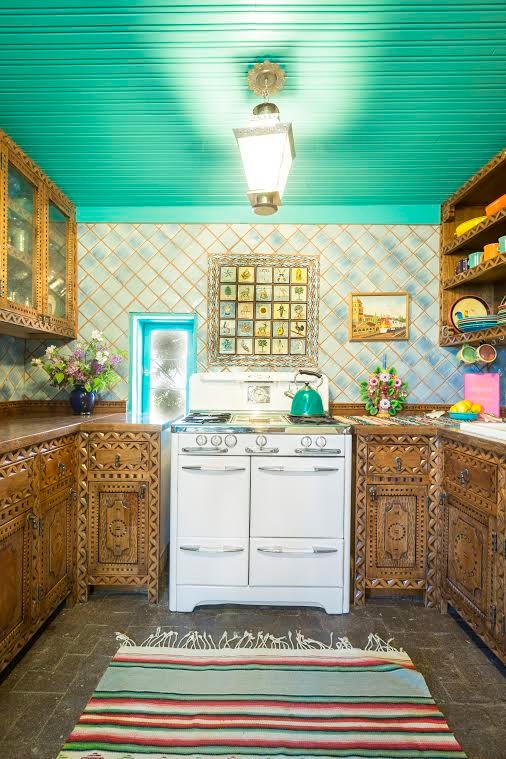 Foto på ett mellanstort, avskilt amerikanskt u-kök, med en dubbel diskho, skåp i mellenmörkt trä, flerfärgad stänkskydd, träbänkskiva, stänkskydd i terrakottakakel, färgglada vitvaror och tegelgolv