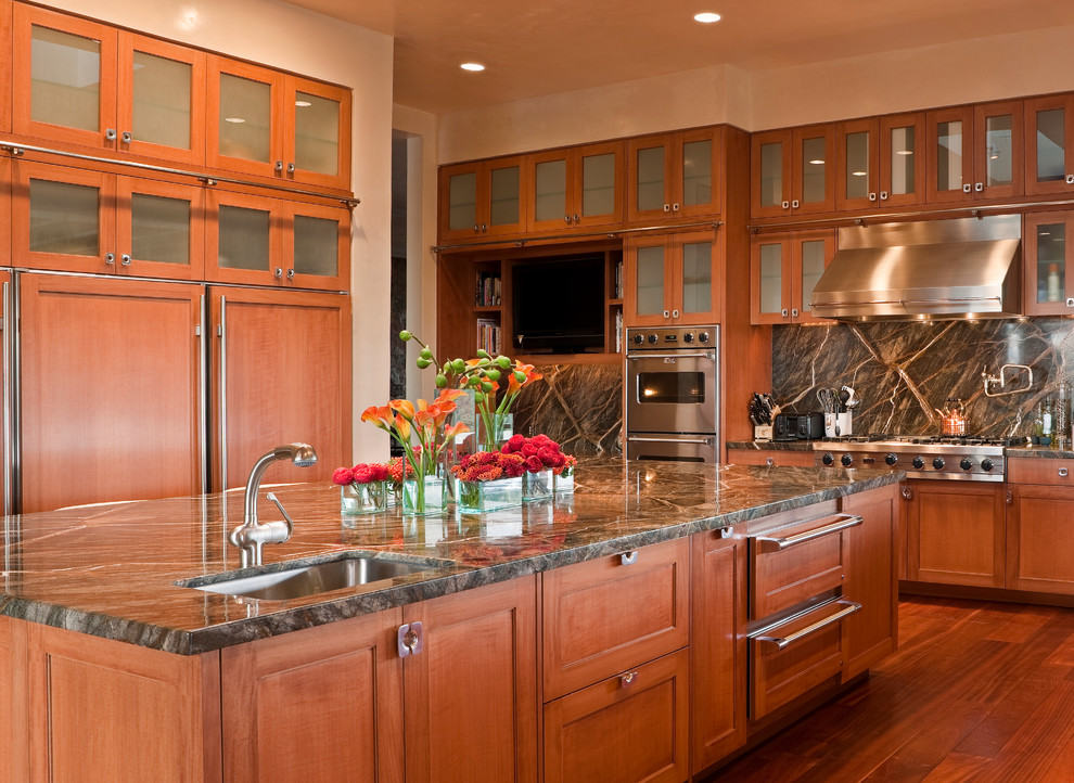 Idéer för att renovera ett stort amerikanskt kök, med en undermonterad diskho, luckor med glaspanel, skåp i mellenmörkt trä, granitbänkskiva, flerfärgad stänkskydd, stänkskydd i sten, rostfria vitvaror, mellanmörkt trägolv, en köksö och brunt golv