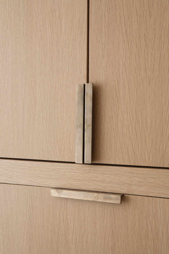 Immagine di una cucina minimalista con ante lisce e ante in legno chiaro