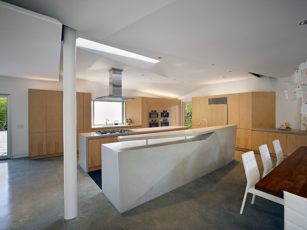 Imagen de cocina minimalista con armarios con paneles lisos, puertas de armario de madera oscura, salpicadero verde, suelo de cemento y suelo gris