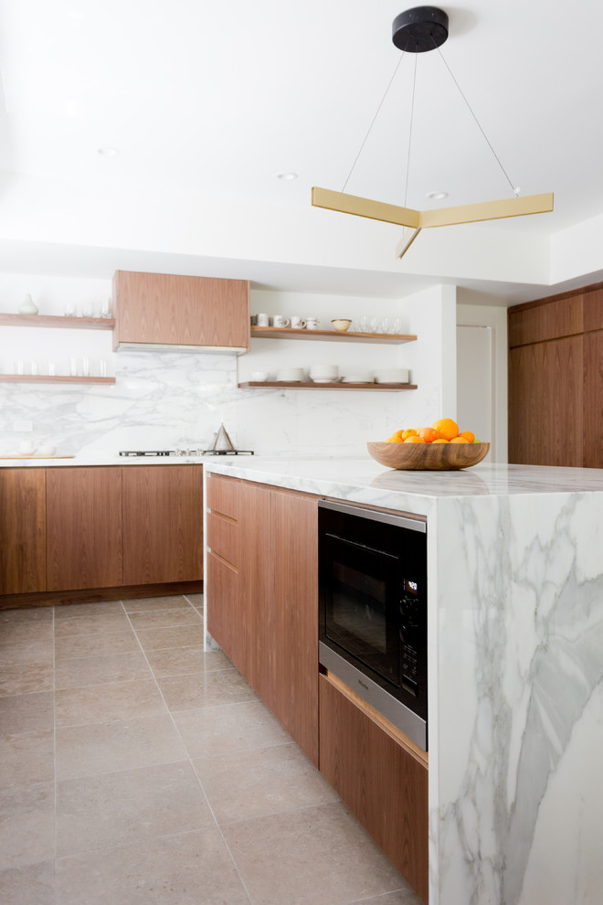 Foto di un cucina con isola centrale contemporaneo con ante lisce, ante in legno bruno, paraspruzzi grigio, paraspruzzi in lastra di pietra, elettrodomestici neri e pavimento beige