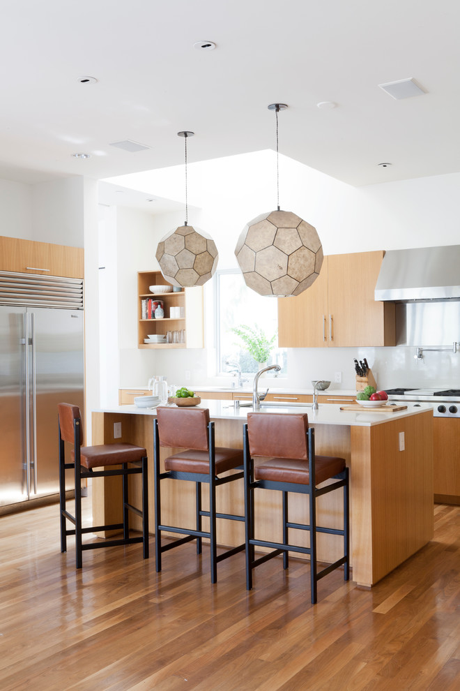 Idee per una cucina parallela contemporanea con ante lisce, ante in legno chiaro e pavimento in legno massello medio
