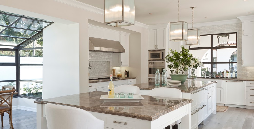 Mediterrane Wohnküche mit weißen Schränken, Küchenrückwand in Grau, Rückwand aus Metrofliesen und Küchengeräten aus Edelstahl in Orange County