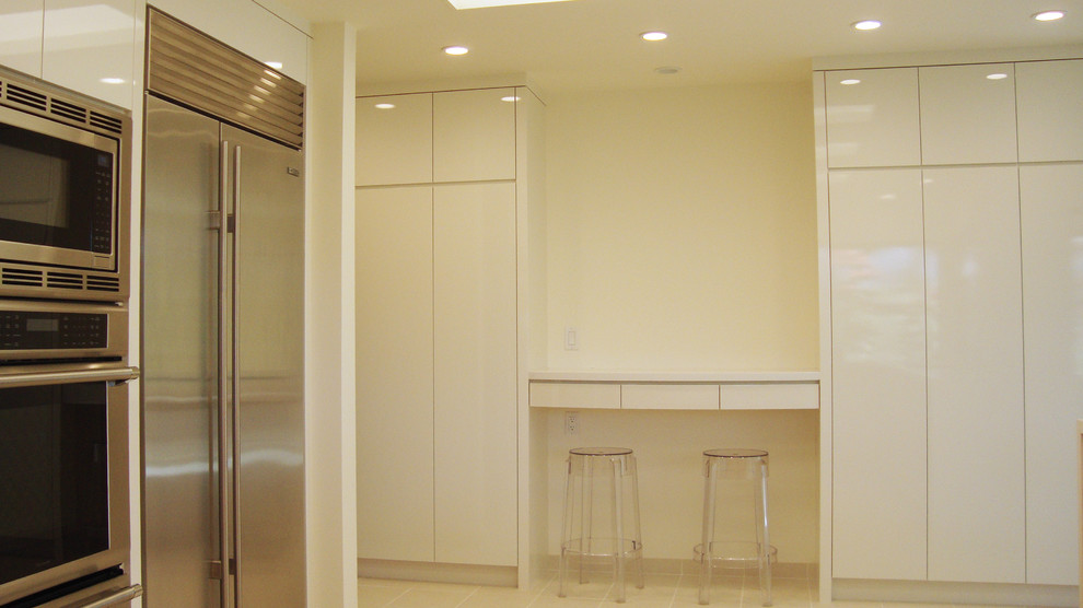 Immagine di una cucina moderna di medie dimensioni con lavello sottopiano, ante lisce, ante bianche, top in quarzite, paraspruzzi bianco, elettrodomestici in acciaio inossidabile, pavimento in gres porcellanato e penisola
