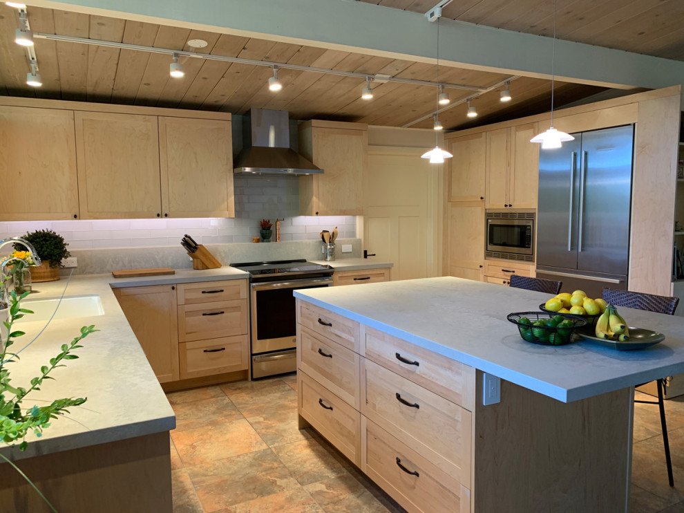 Inredning av ett modernt mellanstort grå grått kök, med en nedsänkt diskho, luckor med infälld panel, skåp i ljust trä, vitt stänkskydd, rostfria vitvaror, en köksö och flerfärgat golv