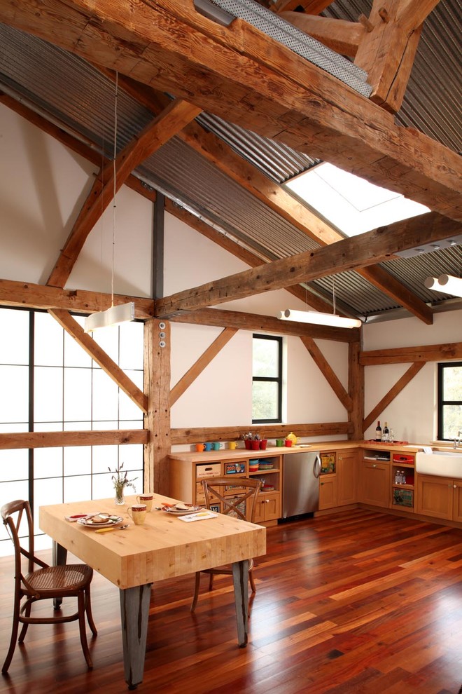 Cette photo montre une cuisine nature en bois brun avec un évier de ferme, un placard à porte shaker, un plan de travail en bois et un électroménager en acier inoxydable.