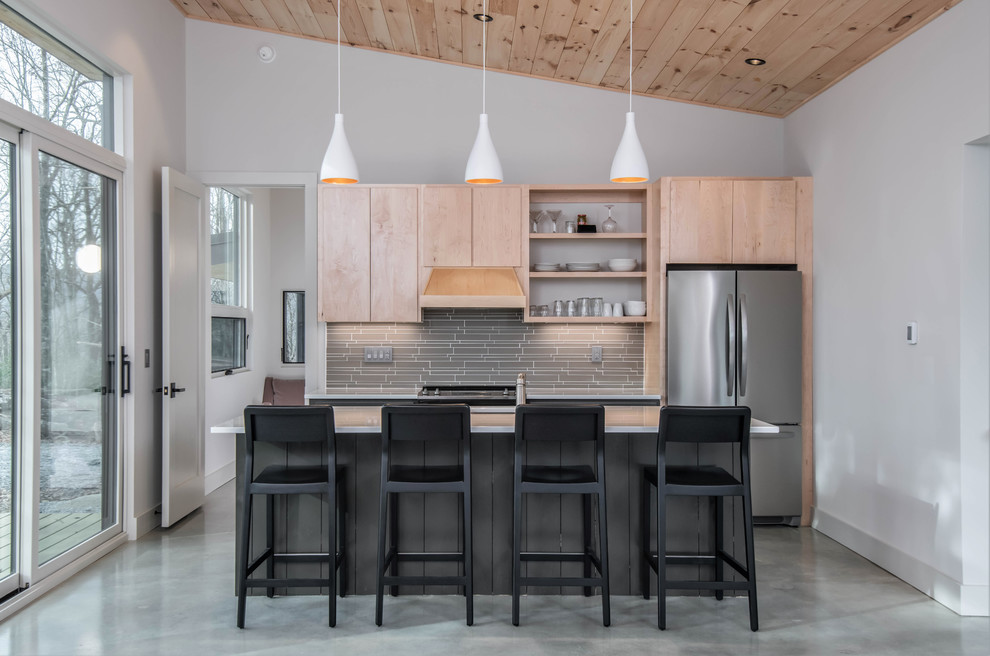 Danish concrete floor and gray floor kitchen photo in Other with an undermount sink, flat-panel cabinets, light wood cabinets, gray backsplash, matchstick tile backsplash, stainless steel appliances, an island and white countertops